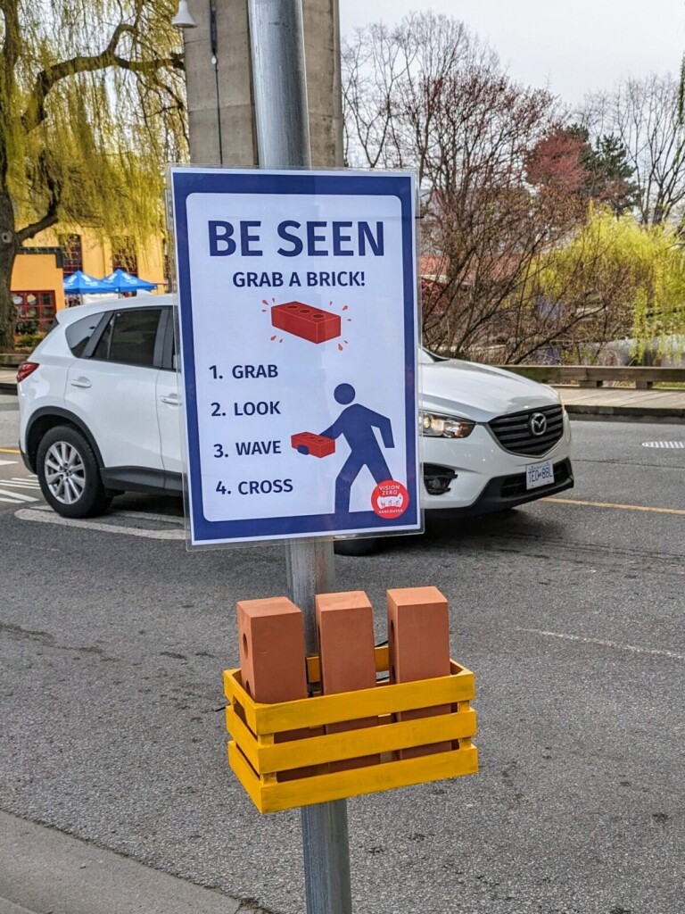 A sign and basket of realistic foam rubber bricks is seen next to
a crosswalk at the entrance to Vancouver’s Granville Island.